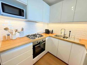 a kitchen with a stove and a sink and a microwave at Spacious Apt with pool & parking in Brisbane