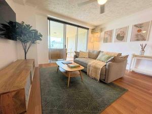 a living room with a couch and a coffee table at Spacious Apt with pool & parking in Brisbane