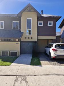een witte auto geparkeerd voor een huis bij Hermosa casa en pucon in Pucón