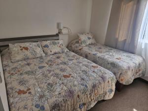een slaapkamer met 2 bedden en een raam met een nachtkastje bij Hermosa casa en pucon in Pucón +5 foto's