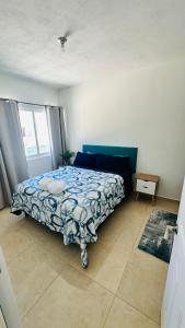 une chambre avec un lit avec une couette bleue dans l'établissement Casa Itzae, à Playa del Carmen