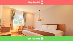 富国BB Hotel&Resort的一间卧室，里面有一张床、一张桌子和一扇窗户。