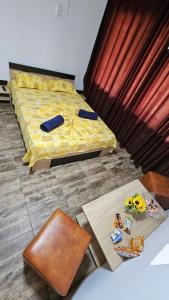 a bedroom with a bed with a yellow comforter at Vila Dana in Costinesti