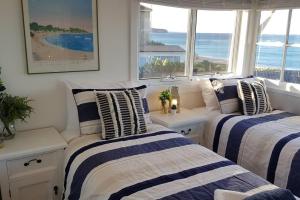 Dos camas en una habitación con vista al mar. en Victorian Beachfront Apartment with Ocean Views - The Coachhouse, en Narrabeen