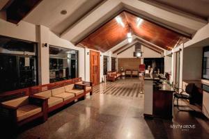 a living room with a couch and a table at Misty Grove Resort Hotel in Gūdalūr