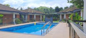 a swimming pool in front of a house at Misty Grove Resort Hotel in Gūdalūr