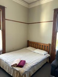 a bedroom with a bed with a blanket on it at Ballymena House in Dunedin
