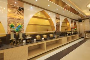 a buffet line in a hotel lobby with gold at Hotel MASAGA by QCENT in Gurgaon