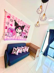 uma sala de estar com um sofá azul e um cobertor rosa em Legoland-3mins Drive KUROMI FAMIY SUITE em Iskandar Puteri mais 37 fotografias