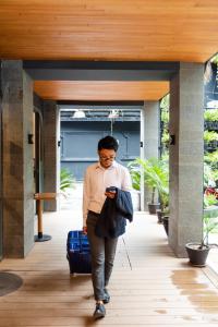 a man walking down a hallway looking at his cell phone at Nomad Hotel in Kathmandu