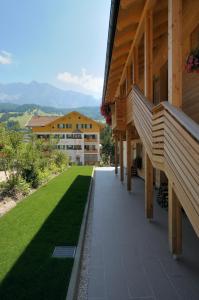 une maison avec une passerelle à côté d'une pelouse verte dans l'établissement Residence Ciasa Mirasas, à Badia