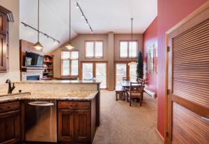 a kitchen with a counter and a dining room at Select Unit 1710 - 2BR - Zephyr Mountain Lodge condo in Winter Park +2 photos