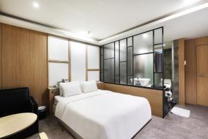 平泽市Pyeongtaek Moon Hotel的一间带一张白色大床的卧室和一间浴室