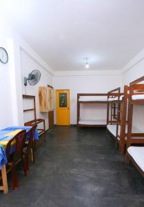 a room with bunk beds and a table and chairs at Yarra BUNKZ Kandy in Kandy +10 photos