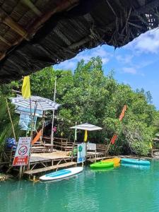 a dock with umbrellas and boats in the water at Virgin River Resort and Recreation Spot in Bolinao +15 photos