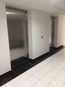 a hallway with two elevators in a building at 2BR Podomoro Golf View Cimanggis with Netflix near exit Toll Jagorawi in Tjikuda Tiga