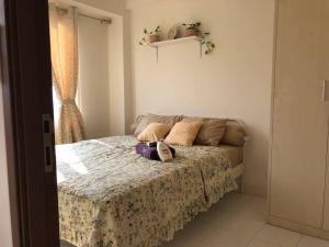 a bedroom with a bed with a purse on it at 2BR Podomoro Golf View Cimanggis with Netflix near exit Toll Jagorawi in Tjikuda Tiga