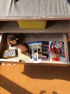 a shelf with books and stuffed animals on it at 2BR Podomoro Golf View Cimanggis with Netflix near exit Toll Jagorawi in Tjikuda Tiga
