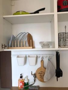 a kitchen shelf with dishes and utensils on it at 2BR Podomoro Golf View Cimanggis with Netflix near exit Toll Jagorawi in Tjikuda Tiga