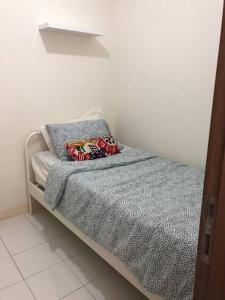 a bed with two pillows on it in a room at 2BR Podomoro Golf View Cimanggis with Netflix near exit Toll Jagorawi in Tjikuda Tiga