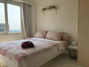 a bedroom with a bed with a purse on it at 2BR Podomoro Golf View Cimanggis with Netflix near exit Toll Jagorawi in Tjikuda Tiga