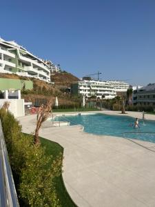 a person swimming in a swimming pool in a resort at Luxury Sea View Apartment Spa Pool Gym La Cala de mijas in Málaga