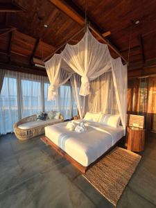 a bedroom with a large bed with a canopy at Full Moon Private Island in Kaoh Sdach