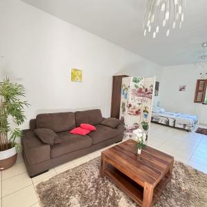 a living room with a couch and a coffee table at SAPHIR-Villa Le Colibri in Dubédou