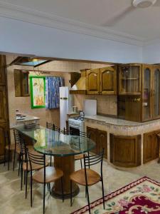 a kitchen with a glass table and some chairs at شالية بقرية بوريفاج 1 in Sarābiyūm