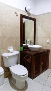 a bathroom with a toilet and a sink and a mirror at Casa Paraíso Maya Bacalar in Bacalar +31 photos