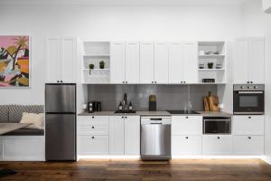 a kitchen with white cabinets and stainless steel appliances at Rainforest Retreat Fireplace, Bath & Falls Walk in Springbrook