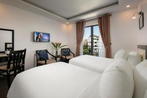 a bedroom with two white beds and a desk and a window at Hoi An Golden Holiday Villa in Hoi An