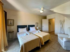 un dormitorio con dos camas y un sofá en Péra Skopelos - Péra ex Maistros, en Skopelos Town 70 fotos más
