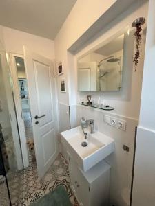 une salle de bain blanche avec un lavabo et un miroir dans l'établissement Mosel Urlaub Stabenhof - Whirlpool, Natur und Grill, à Brodenbach