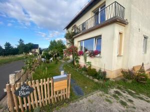 une maison avec une clôture en bois devant dans l'établissement Mosel Urlaub Stabenhof - Whirlpool, Natur und Grill, à Brodenbach
