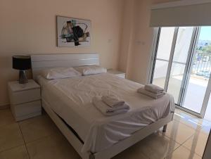 a bedroom with a bed with towels on it at Adalena Court in Protaras