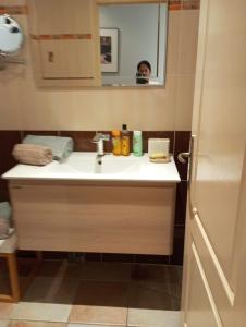 a bathroom with a sink and a person in the mirror at Villa Primerose Guest House in Saint-Raphaël