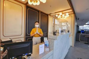 a woman standing at a counter with a mask on her face at Patra Malioboro Hotel in Yogyakarta +81 photos