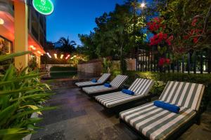 a row of lounge chairs sitting outside of a building at Hoi An Golden Holiday Villa in Hoi An