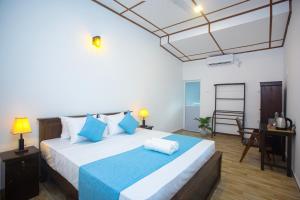 a bedroom with a large bed with blue pillows at Echoing Dream Resort in Galle +66 photos