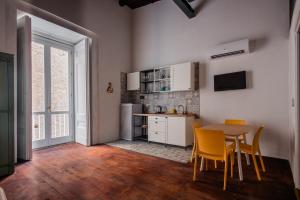 kuchnia ze stołem i krzesłami w pokoju w obiekcie Velato Carafa Palace By Dimorra w mieście Neapol