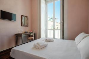 sypialnia z łóżkiem i ręcznikami w obiekcie Velato Carafa Palace By Dimorra w mieście Neapol