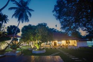 a house with a courtyard with trees and chairs at Echoing Dream Resort in Galle