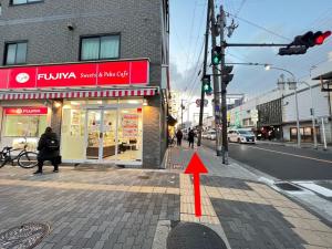 a red arrow pointing to a store on a city street at 星の宿 in Osaka