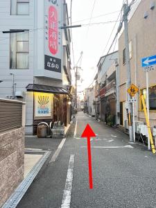 an empty street with a red arrow on the road at 星の宿 in Osaka +21 photos