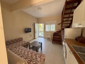 a living room with a couch and a table in a kitchen at Sea View Maison - Nea Potidea - Chalkidiki in Nea Potidaea