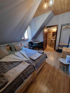 une chambre avec un grand lit dans un grenier dans l'établissement TatroManiac Zakopane Pokoje, à Zakopane 83 autres photos