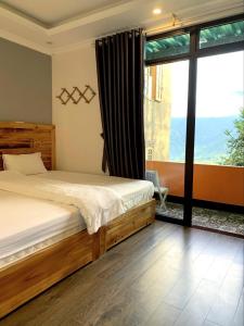 a bedroom with a bed and a large window at Daun Pisang Homestay & Halal Food in Sapa