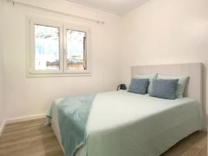 ein weißes Schlafzimmer mit einem großen Bett mit blauen Kissen in der Unterkunft The Mountain House experience in Rio Caldo