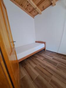 a small room with a bed and a wooden floor at Guest house SARA in Čapljina